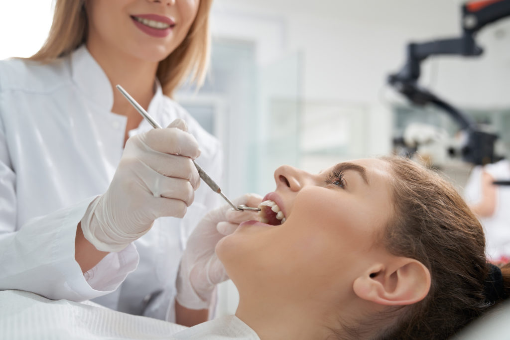 dentist treating woman 39 s teeth in dentistry RLVW39T